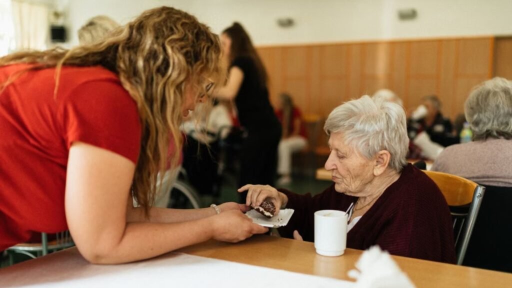 A woman serving a elderly woman some food_Medication Aide Training