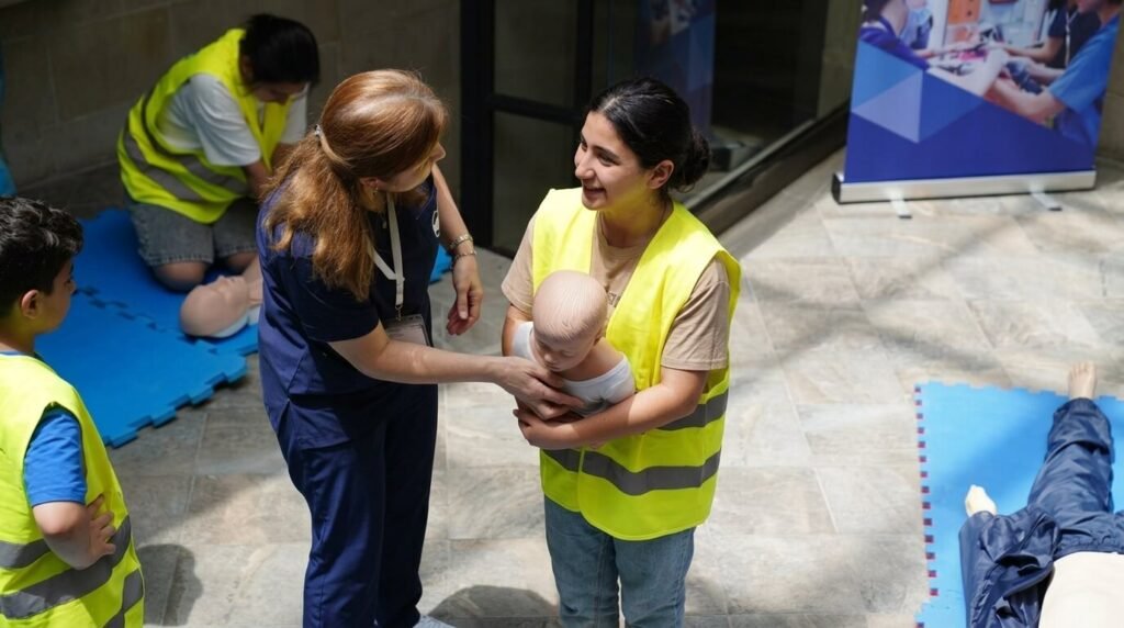 a girl holding a dummy at a cpr training site