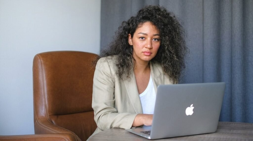 a woamn sitting alone in an office at a computer