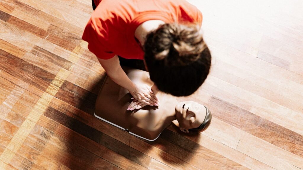 a woman practicing cpr by compressing the chest of a dummy