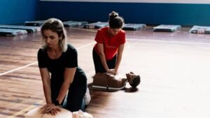two women doing cpr training on dummies during Family and Friends CPR class